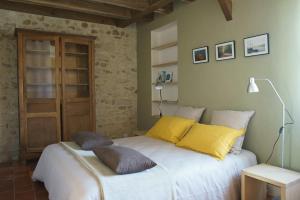 a bedroom with a large white bed with yellow pillows at L'Abeille bleue in Cheillé