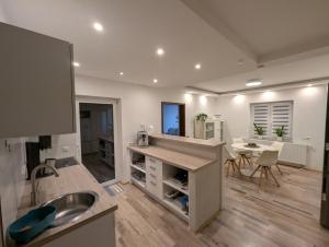 a kitchen with a sink and a counter with a table at Ferienwohnung Erlengrund in Mochenwangen