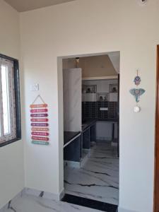 a kitchen with white walls and a sign on the wall at Lotus Villa Hampi in Hospet +11 photos