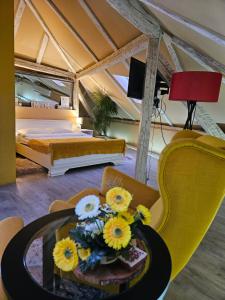 a bedroom with a bed and a table with flowers on it at Laci Lak in Oradea