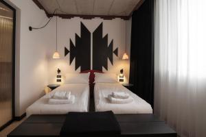a bedroom with two beds and a black and white wall at BAZAAR HOTEL Center in Tirana