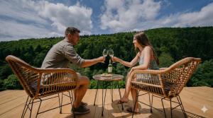 a man and woman sitting at a table with glasses of wine at Domček Lazy in Štôla