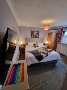 a bedroom with a bed with a rainbow blanket at Pride Lodge in Blackpool +41 photos
