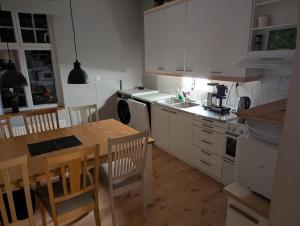 a kitchen with a table and chairs and a kitchen with a sink at Björk City - Charmig lägenhet nära centrum in Pietarsaari