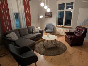 a living room with a couch and two chairs and a table at Björk City - Charmig lägenhet nära centrum in Pietarsaari
