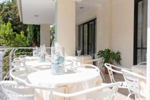 a row of white tables and chairs on a balcony at Hotel MIRO' in Cattolica