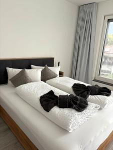 a bed with white sheets and black clothes on it at DAS LUDWIG - Haus HOCHLAND in Garmisch-Partenkirchen