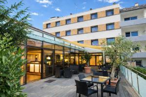 an outdoor patio with tables and chairs in front of a building at Luna Inn Stuttgart City in Stuttgart