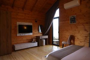 a bedroom with a bed and a tv on the wall at Kriva Resort in Elbasan