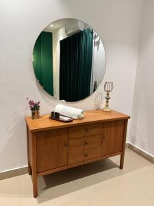 a bathroom with a wooden dresser and a mirror at Staye in Islamabad