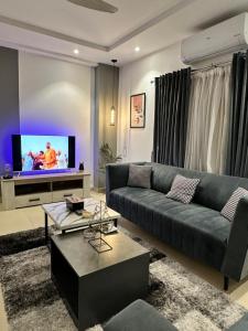 a living room with a couch and a tv at Staye in Islamabad