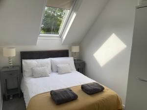 a bedroom with a bed with two pillows on it at Lakescape in Cirencester