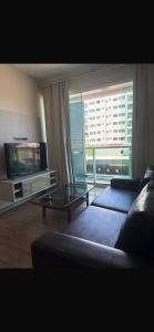 a living room with a couch and a glass table at Dois quartos centro in Ubá +19 photos