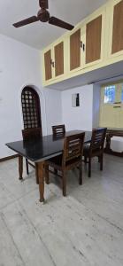 a dining room with a table and two chairs at Thaayar Homestay by Highpoint in Tiruchirappalli