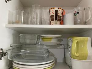 a shelf with dishes and other kitchen utensils at Dois quartos centro in Ubá