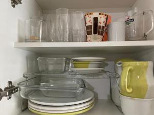 a shelf with plates and bowls and other dishes at Dois quartos centro in Ubá