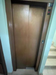 a brown elevator door in a hallway with stairs at Hotel Victorino in Silleda