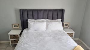 a bedroom with a large bed with white sheets and pillows at Riley's Place in Cape Town