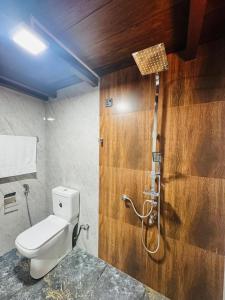 a bathroom with a toilet and a shower at Sinharaja Brook Cabana in Deniyaya