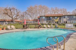 a large swimming pool with chairs and umbrellas at Pleasanton Gem in Quiet Community w/ Pool Access in Pleasanton
