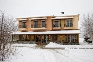 a house with snow on the ground in front of it at Ducata Hotel - Xirolivado in Xirolívadon