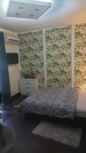 a bedroom with a bed with a floral wallpaper at Nena Studio in Jagodina +16 photos
