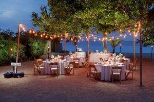 a table set up for a wedding under a tree with lights at Couples Negril in Negril