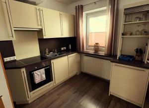 a kitchen with white cabinets and a sink and a window at Loipersdorf Living - Golf & Therme in Loipersdorf bei Fürstenfeld