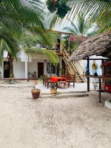 a resort with a table and chairs on the beach at Paje lounge in Paje