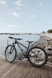 a bike parked on a boardwalk next to the water at NINE DOTS Azorean Art Boutique Hotel in Ponta Delgada