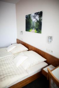 a bed with white pillows in a room at Hotel-Cafe Römer in Siegen