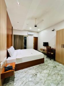 a hotel room with a bed and a desk and a computer at Neem Residency in Erāttupetta