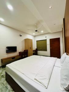 a bedroom with a large bed and a flat screen tv at Neem Residency in Erāttupetta