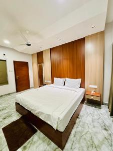 a bedroom with a large bed with a wooden wall at Neem Residency in Erāttupetta
