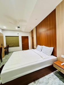 a bedroom with a large white bed in a room at Neem Residency in Erāttupetta