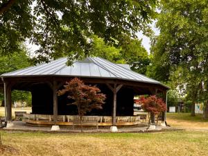 a gazebo with a black roof in a park at Ferienwohnung La Bohème in Bad Königshofen im Grabfeld