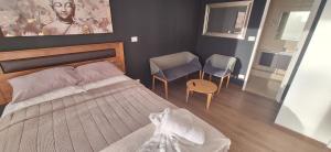 a bedroom with a bed and two chairs at Apart Hotel Castellon 176 in Concepción