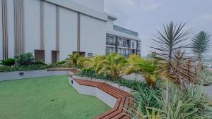 a building with palm trees and plants in front of it at The Loxwood House Studio in East Legon