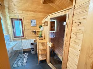 a bathroom with a toilet and a sink in a wooden cabin at Sky-View Chalet am Waldsee in Rieden +20 photos