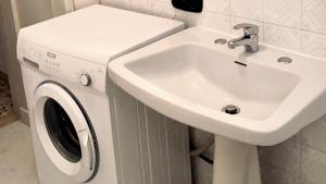 a white sink and a washing machine in a bathroom at RM05 - Senigallia, trilocale fronte mare in Senigallia