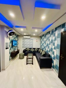 a living room with a black couch and blue ceilings at Bahria 777 Luxury Apartment in Lahore
