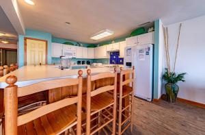 a kitchen with white cabinets and a large island at Sunny Delight - KDH MP 7, Ocean View, 130 Yds to Beach, Pool, Hot Tub, Pets OK, Flex Stays in Kill Devil Hills +52 photos