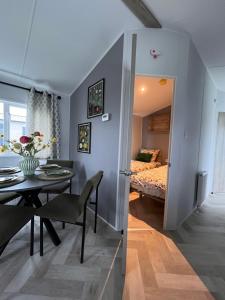 a room with a dining table and a bedroom at B&B Voor De Zee in Westerland