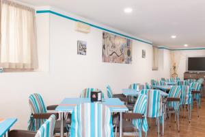 a dining room with blue tables and chairs at Hotel MIRO' in Cattolica