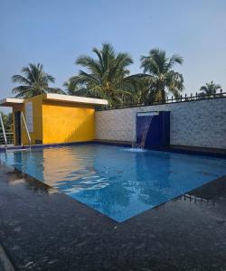 a swimming pool with a waterfall in front of a building at Villa platinum 4 Bhk in Calangute