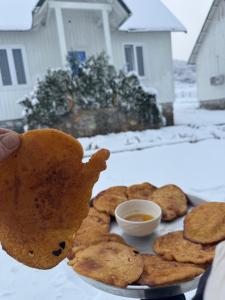 a plate of cookies with a hand holding a teddy bear at Koçeku Brothers Guest House in Fushë-Lurë