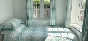 a bedroom with a bed in front of a window at Coach house in Enderby
