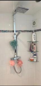 a bathroom with a faucet on a white tiled wall at Coach house in Enderby