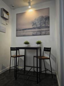 a table with two chairs and a painting on the wall at Cozy Room G10 in Valencia