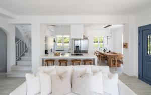 a living room and kitchen with a white couch at Lourdas White Villa in Kefallonia
